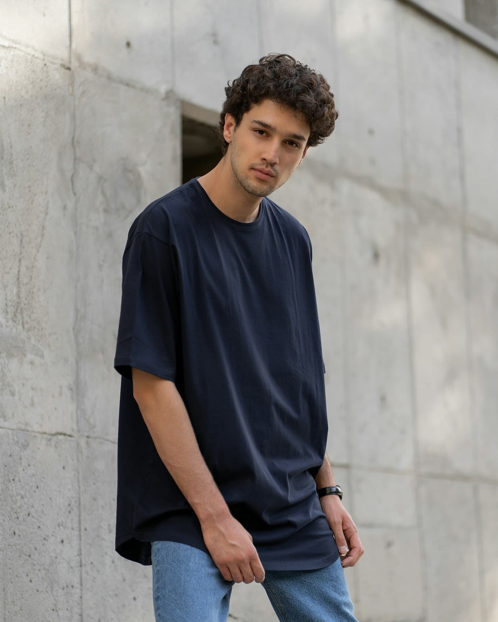 Pessoa vestindo camiseta oversized azul-marinho lisa